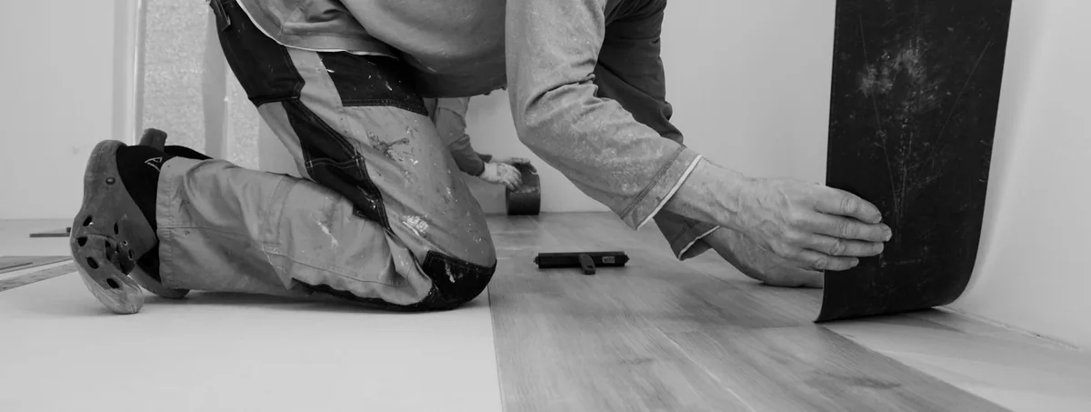 Installer laying new plank flooring by hand